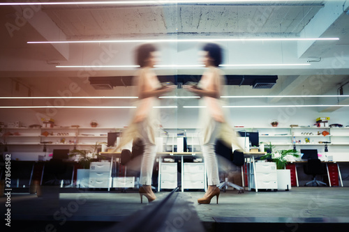 Professional business woman in motion with blur in business office