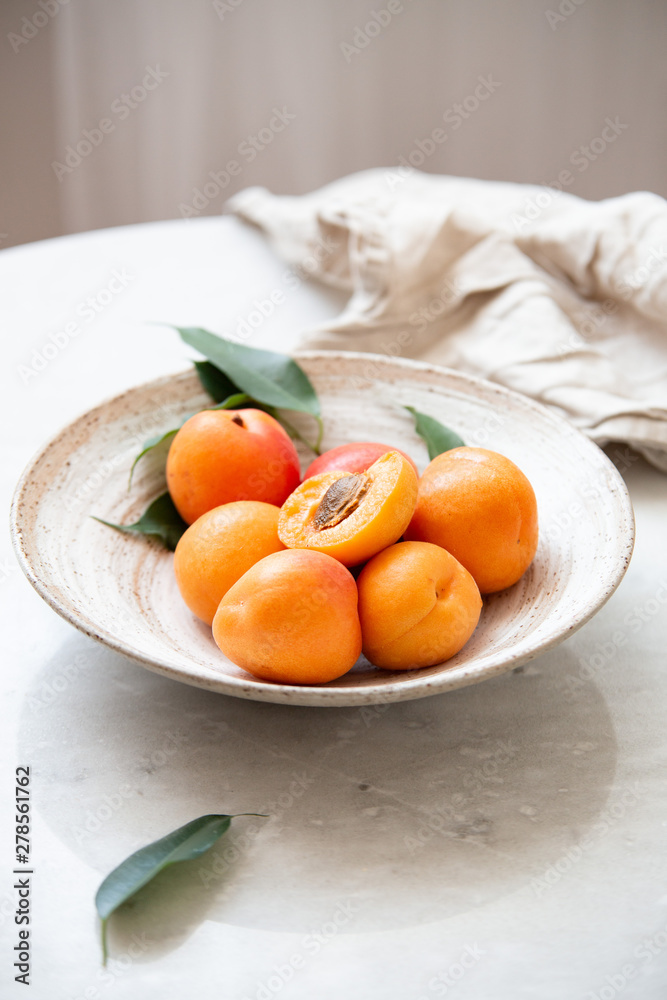 Wicker basket apricot on a marble background with copy space and daylight Wicker basket apricot on a marble background with copy space and daylight