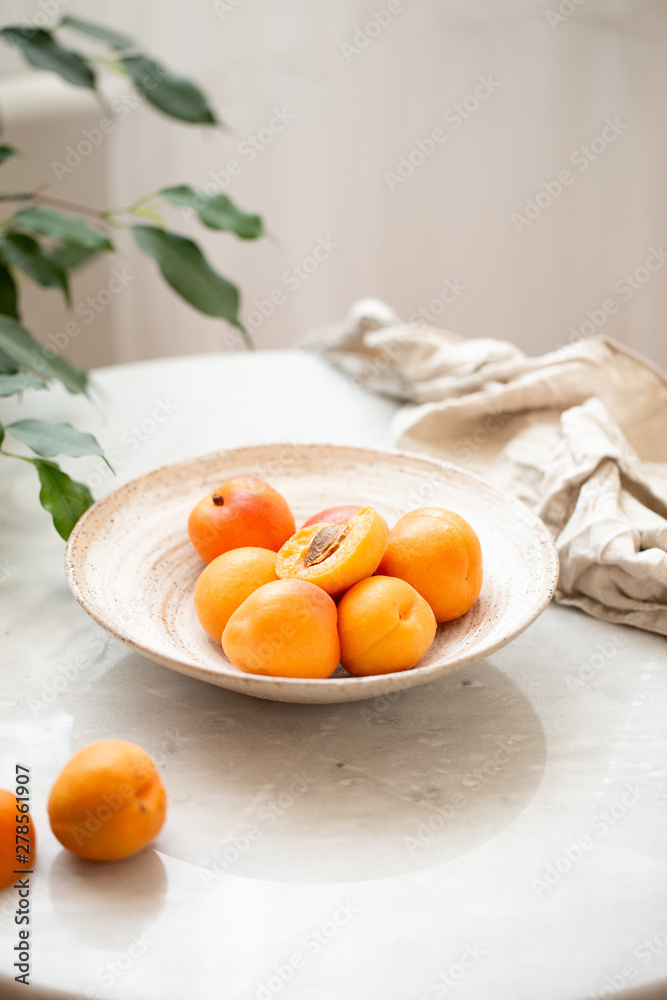 Wicker basket apricot on a marble background with copy space and daylight Wicker basket apricot on a marble background with copy space and daylight