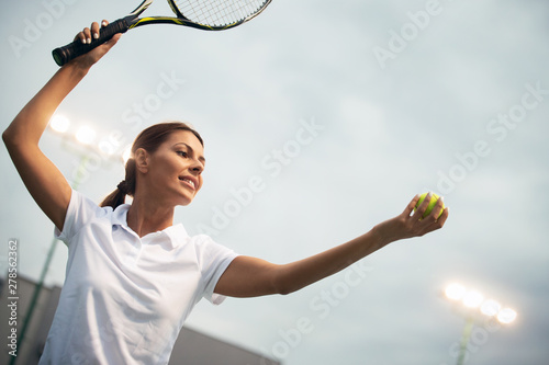 Tennis player prepares to serve ball during tennis match © NDABCREATIVITY