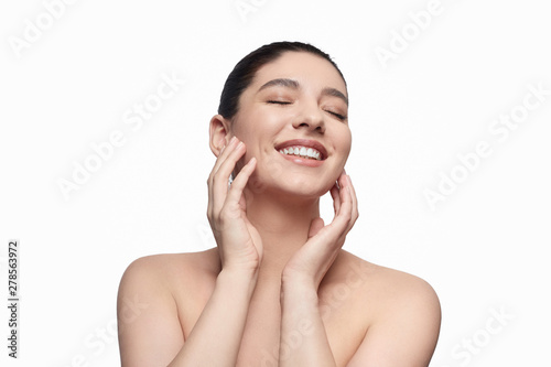 Cheerful lady touching clean face