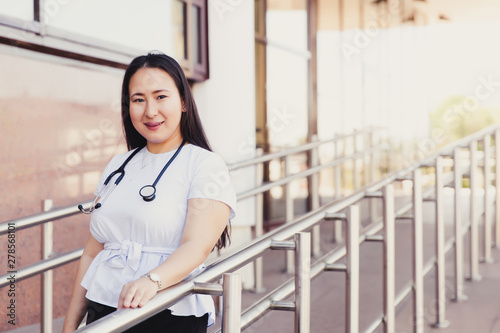 Closeup portrait of friendly female asian medical student. People - a doctor, a nurse and a surgeon on the background of the university's educational clinic. Health insurance. Medical Education