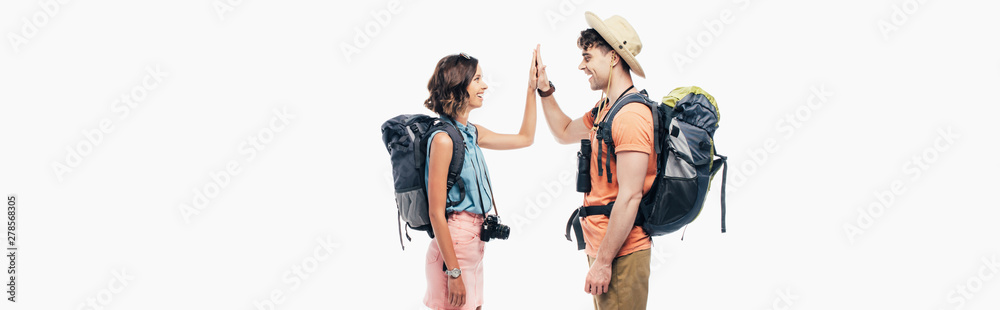panoramic shot of two young tourists with backpacks giving high five isolated on grey panoramic shot of two young tourists with backpacks giving high five isolated on grey