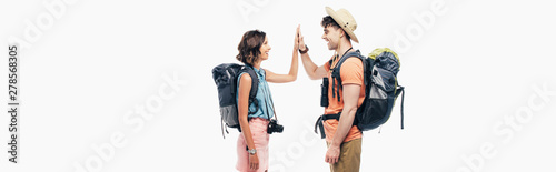 panoramic shot of two young tourists with backpacks giving high five isolated on grey