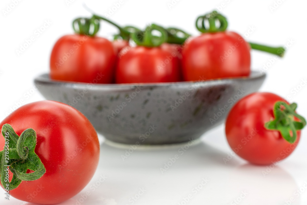 Group of seven whole fresh red tomato cherry front focus on a ceramic grey plate isolated on white background Group of seven whole fresh red tomato cherry front focus on a ceramic grey plate isolated on white background
