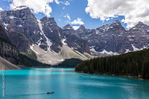 Tourists canoeing in the beautiful turquoise waters of Moraine Lake, embraced by the Valley of the Ten Peaks in Banff National Park, Alberta, Canada