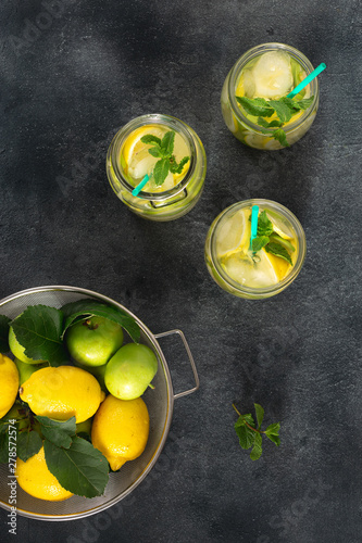 Citrus fruit summer drink concept. Sugar free fresh lemonade with apples and lemon on a dark background top view