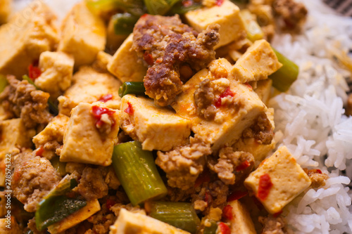 Mapo Doufu also known as Mapu Tofu, a spicy Asian dish made from minced meat and tofu cubes with spring onions and lots of chili, close up photo