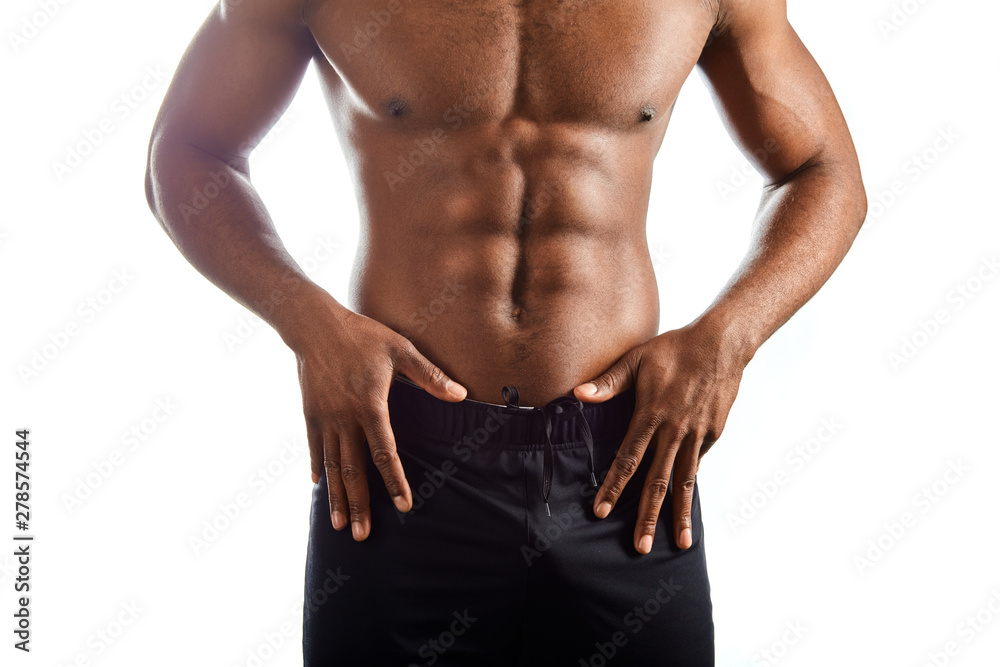 close up cropped photo. afro man advertising his trousers, shorts. athlete showing his abs after training. result of daily workout. isolated white background close up cropped photo. afro man advertising his trousers, shorts. athlete showing his abs after training. result of daily workout. isolated white background