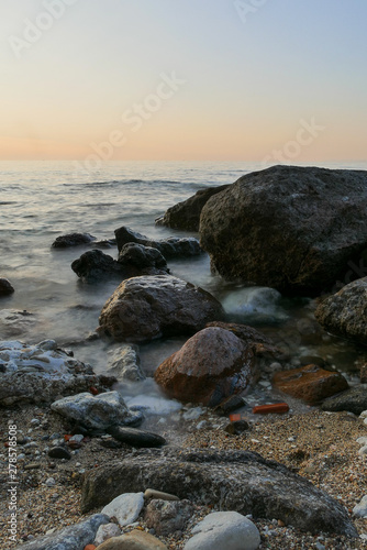 black rocks in the sea. clear coastline with sunset