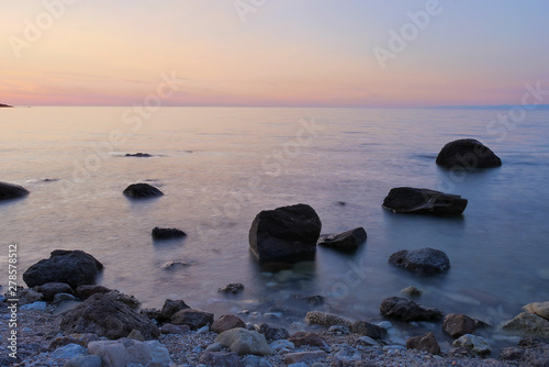 sunset at sea with rocks and colorful sky
