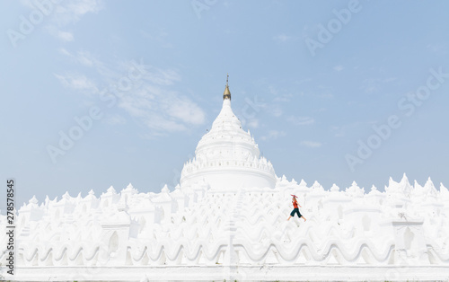 Blonde Caucasian woman with red umbrella walking on the walls of Myatheindan Pagoda in Mandalay  Myanmar