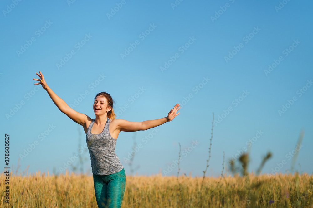 Happy woman on sunset or sunrise. Female runner raising arms expressing positivity and success. Happy woman on sunset or sunrise. Female runner raising arms expressing positivity and success.