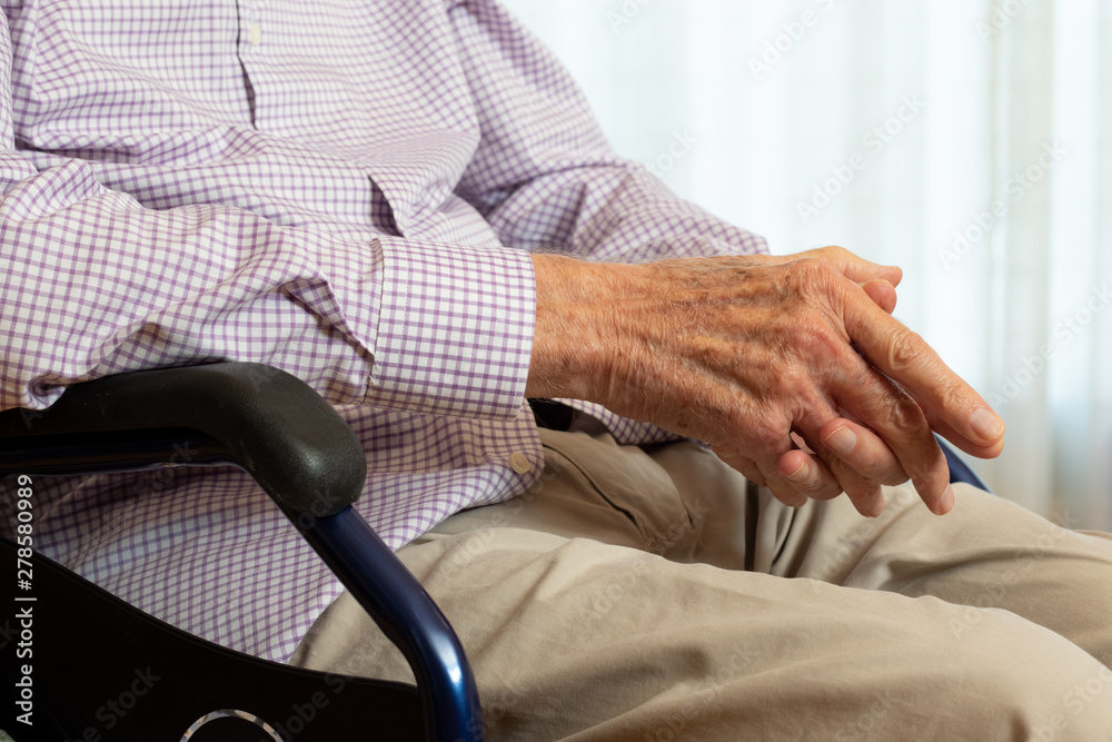 Detail of old man's hands in wheelchair.
