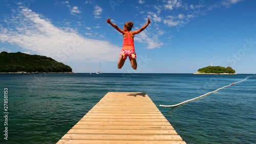 woman jumping from the pontoon, croatia photo