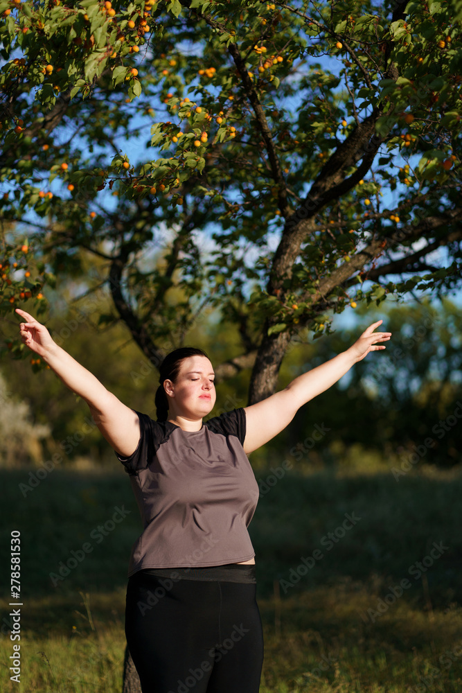 Happy woman standing in nature with open hands. Self esteem, body positive, life goals concept