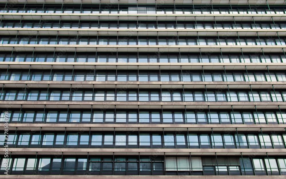 the facade of a office building with many windows arranged in a line,