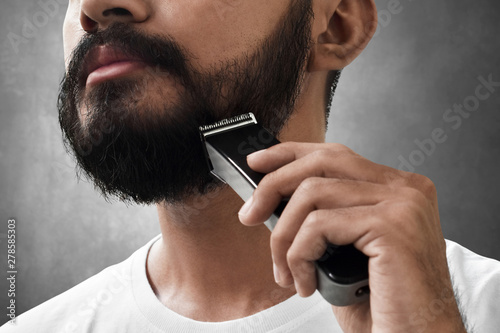 Bearded man shaving his beard photo