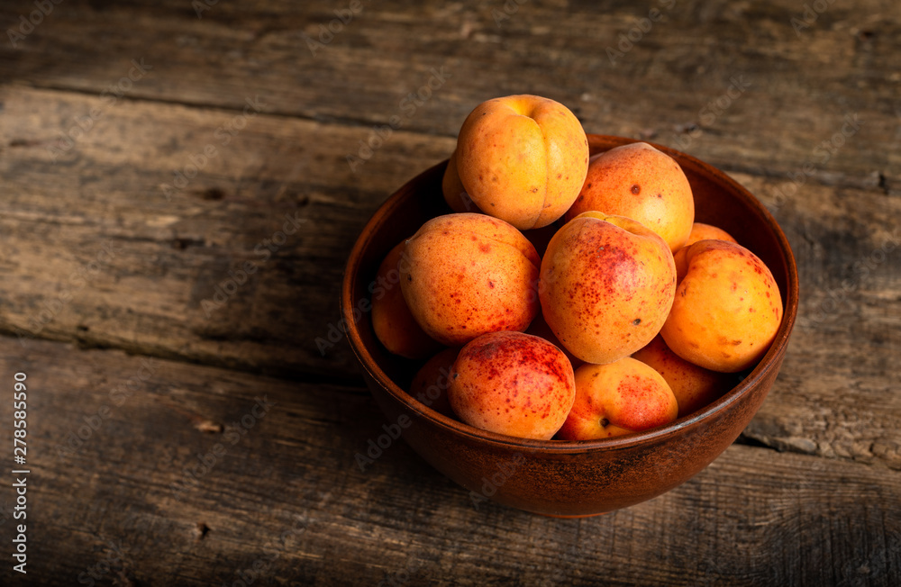 fresh apricots in a basket on a wooden table fresh apricots in a basket on a wooden table