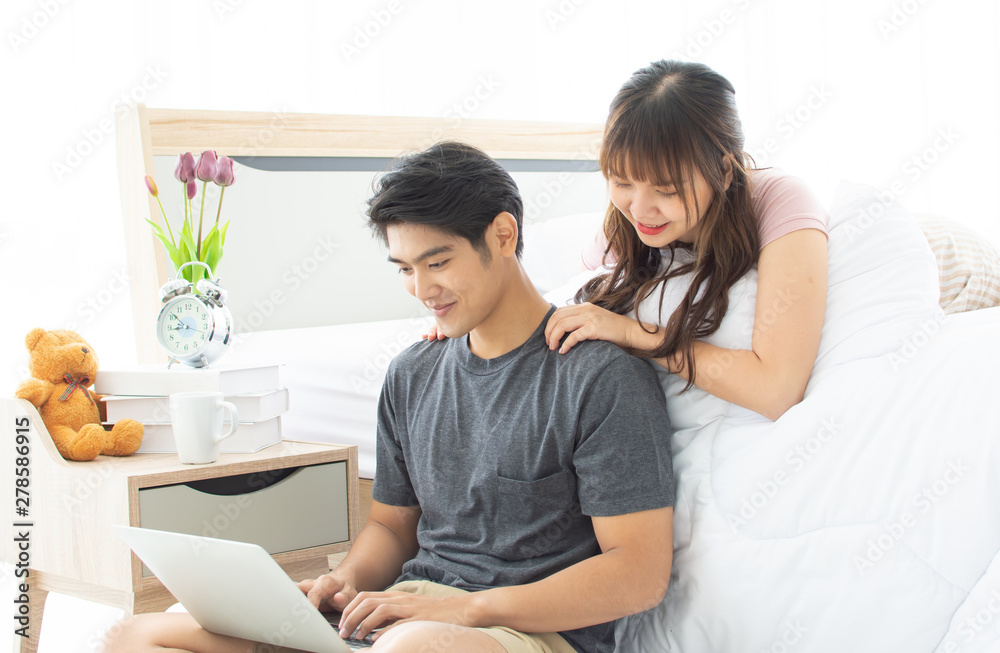 A couple is searching internet in bedroom A couple is searching internet in bedroom