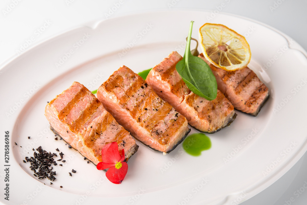 Grilled fish fillet salmon. Selected pieces of red fish. Seafood. Banquet festive dishes. Fine dining restaurant menu. White background. Grilled fish fillet salmon. Selected pieces of red fish. Seafood. Banquet festive dishes. Fine dining restaurant menu. White background.