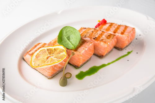 Grilled fish fillet salmon. Selected pieces of red fish. Seafood. Banquet festive dishes. Fine dining restaurant menu. White background.
