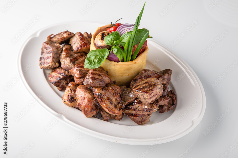 Skewers of pork, beef with vegetables and mushrooms. Grilled meat. Banquet festive dishes. Fine dining restaurant menu. White background. Skewers of pork, beef with vegetables and mushrooms. Grilled meat. Banquet festive dishes. Fine dining restaurant menu. White background.