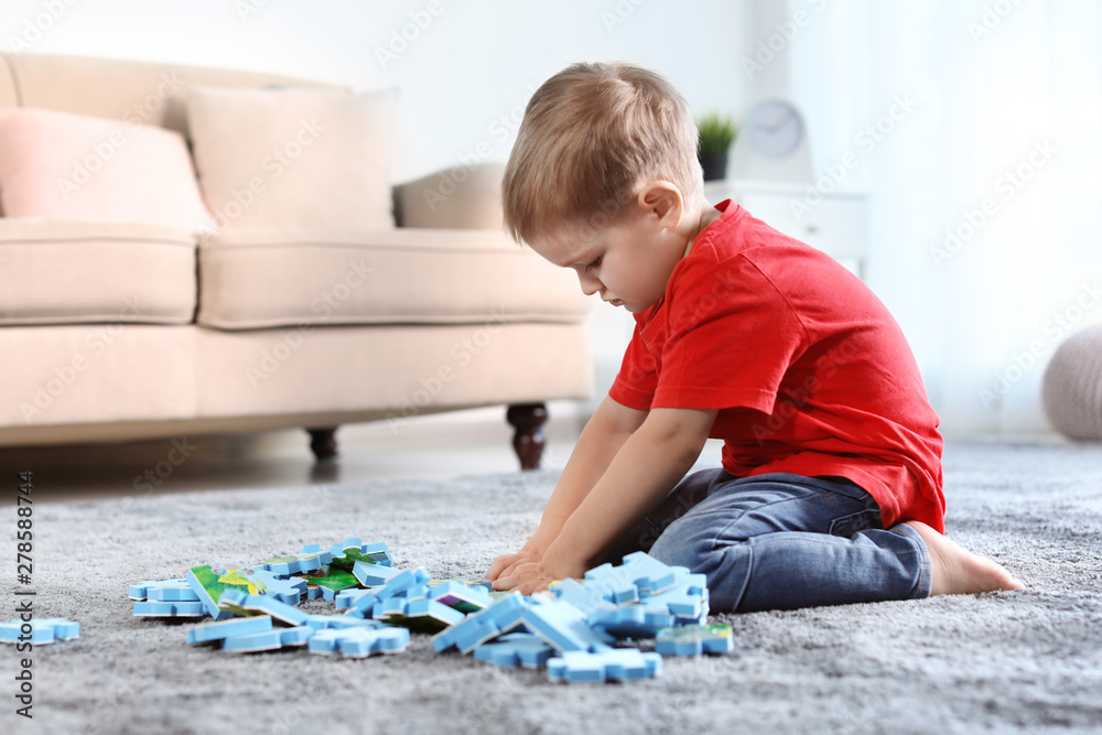 Cute little child playing with puzzles on floor indoors. Space for text Cute little child playing with puzzles on floor indoors. Space for text