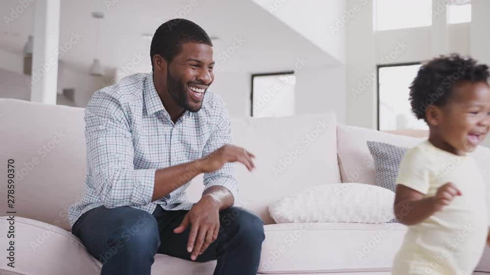 Baby Daughter Gives Father High Five As They Play Game At Home Together Baby Daughter Gives Father High Five As They Play Game At Home Together