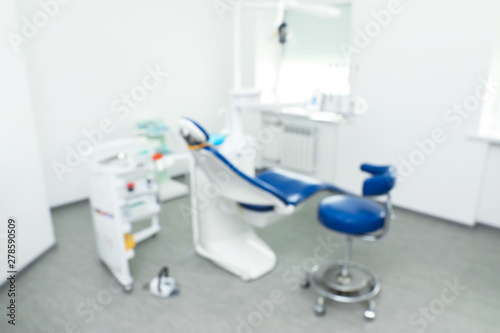 Blurred view of dentist s office interior with chair and equipment
