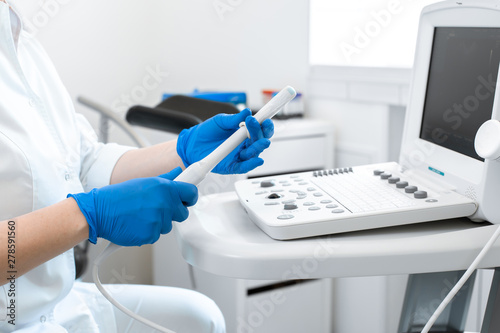 gynecologist puts a condom on the ultrasound sensor to examine the internal organs of the patient s pelvis