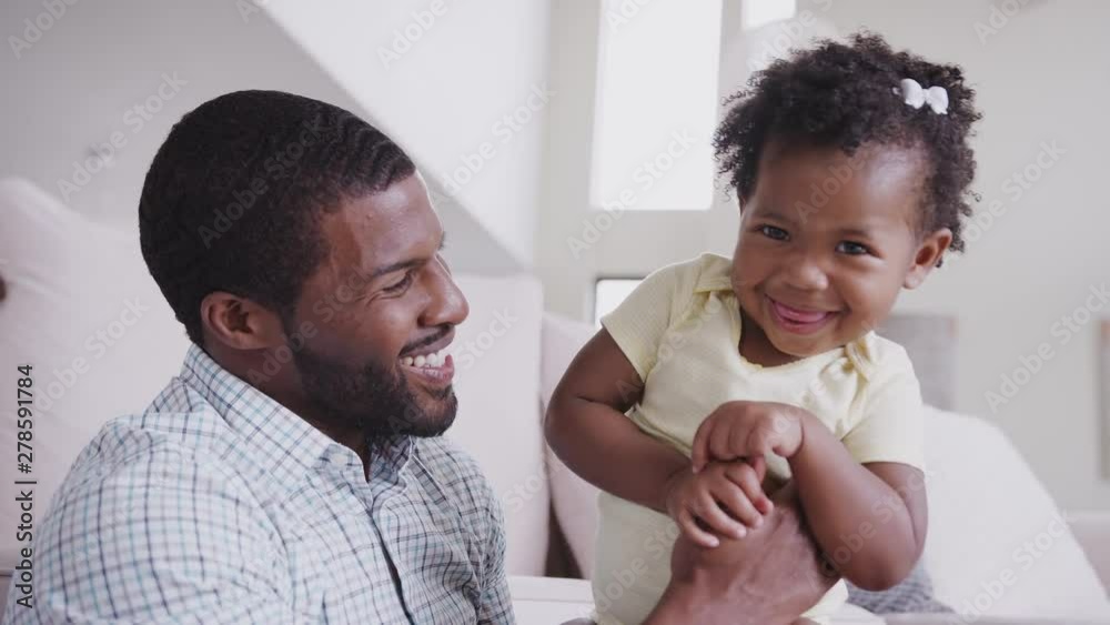 Father Playing With Baby Daughter Tickling Her At Home Father Playing With Baby Daughter Tickling Her At Home
