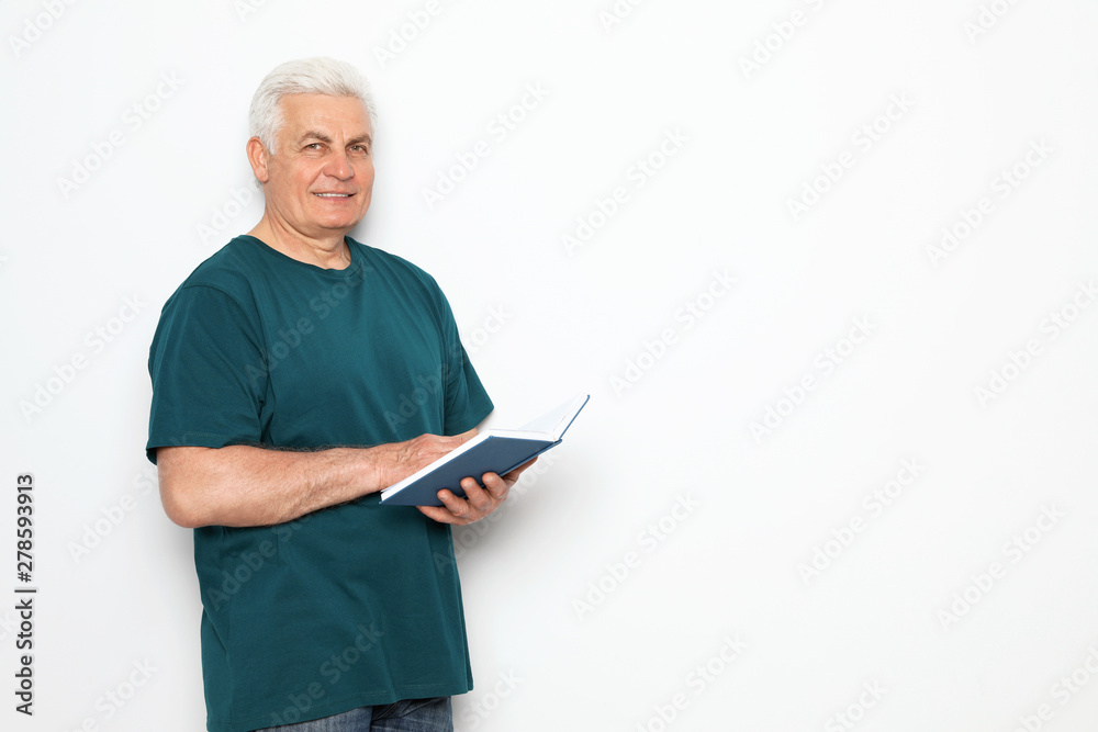 Senior man reading book on white background, space for text Senior man reading book on white background, space for text