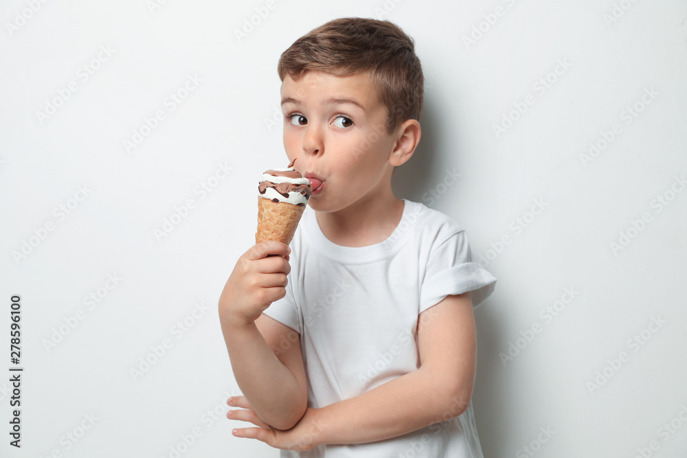 Adorable little boy with delicious ice cream against light background Adorable little boy with delicious ice cream against light background