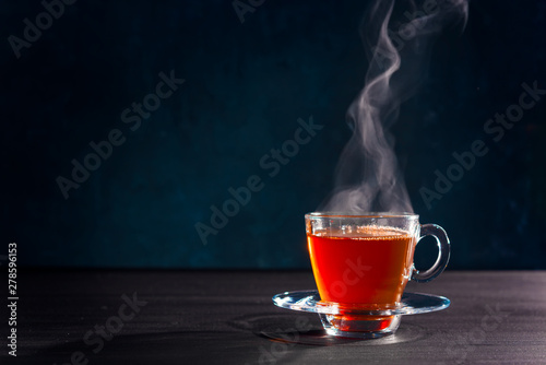 Freshly brewed black tea in a transparent glass Cup,escaping steam