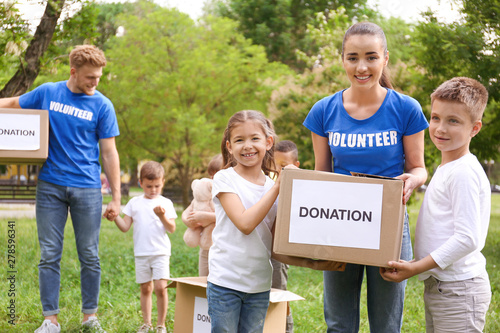 Volunteers and kids with donation boxes in park