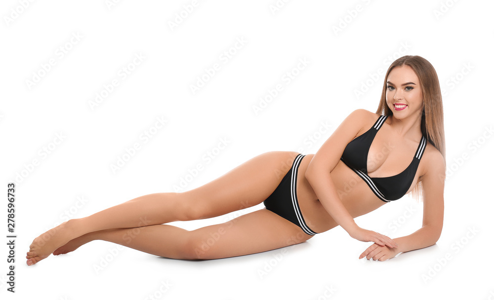 Pretty sexy woman with beautiful slim body in stylish bikini lying on white background
