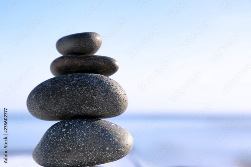 Stack of dark stones against blurred background, space for text. Zen concept Stack of dark stones against blurred background, space for text. Zen concept