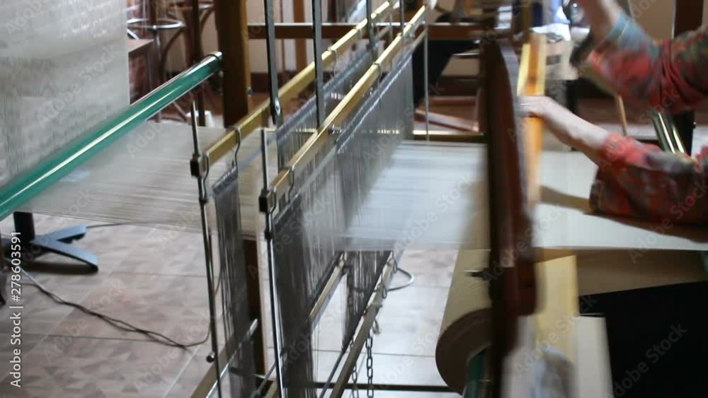 Traditional silk fabric loom. Old silk fabric weaving machine. Woman weaving silk fabric on loom. With sound