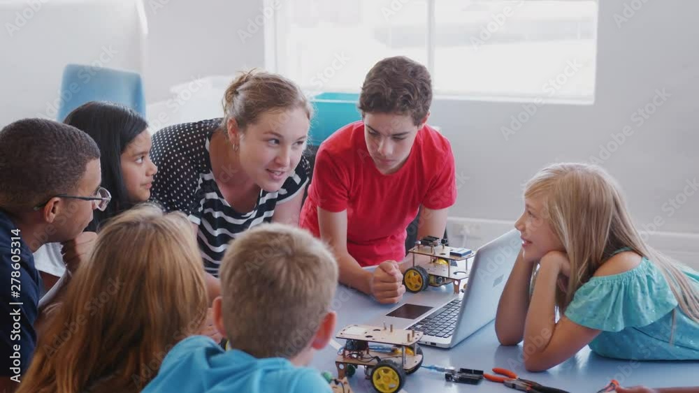 Students With Teachers In After School Computer Coding Class Learning To Program Robot Vehicle Students With Teachers In After School Computer Coding Class Learning To Program Robot Vehicle