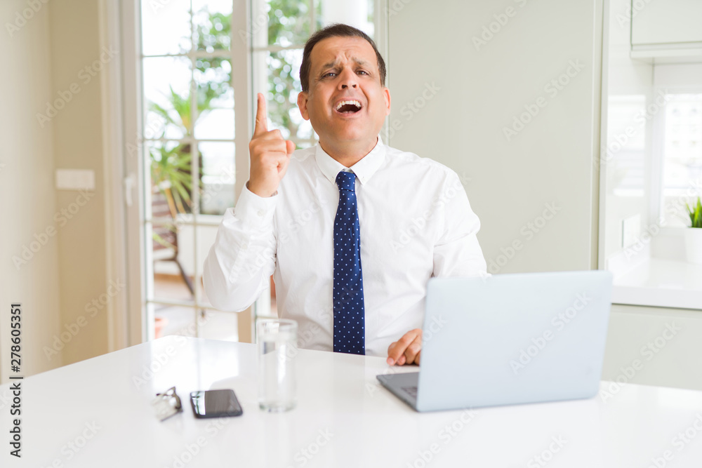 Middle age business man working with computer laptop pointing finger up with successful idea. Exited and happy. Number one. Middle age business man working with computer laptop pointing finger up with successful idea. Exited and happy. Number one.