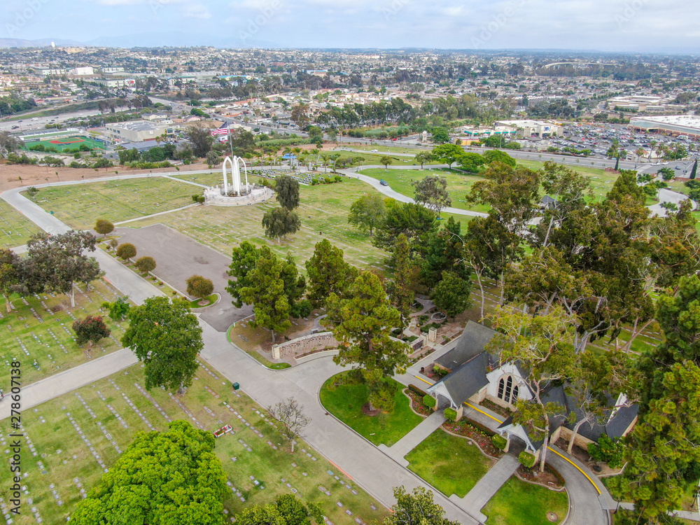 Aerial view of Greenwood Memorial Park & Mortuary. Memorial statue with American flag. Funeral, cemetery in San Diego, California, USA. 