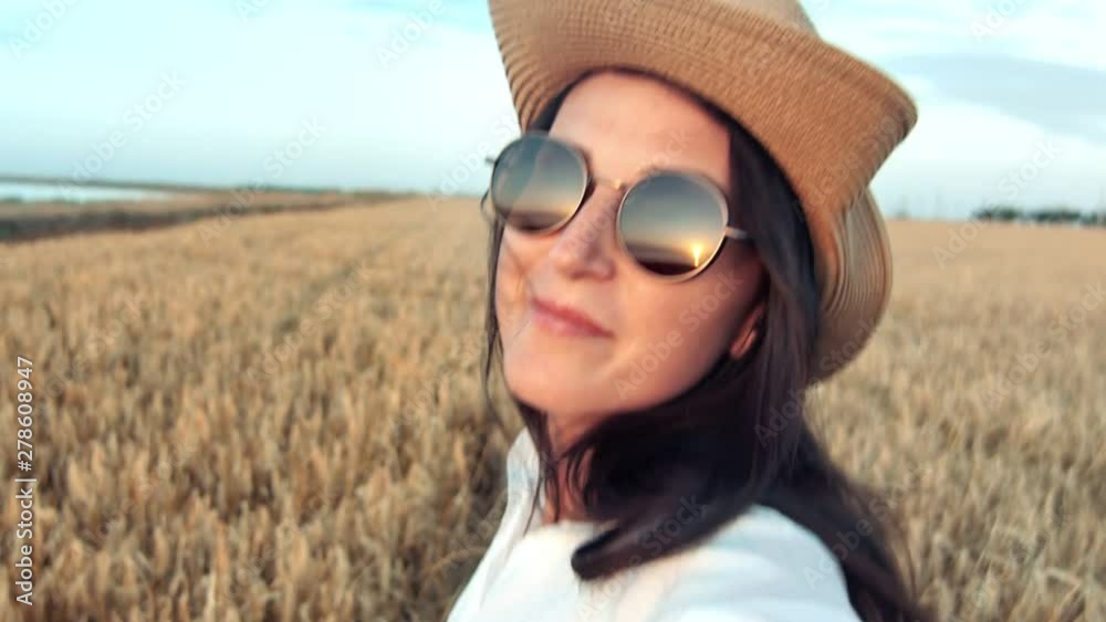 Smiling face fashion travel woman running on wheat field and turning head at sunset enjoying freedom Smiling face fashion travel woman running on wheat field and turning head at sunset enjoying freedom