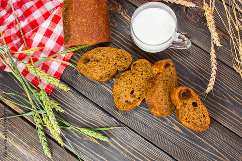 Fototapeta Naklejka Na Ścianę i Meble -  Freshness homemade bread with cup of milk on wooden background. Healthy organic food concept