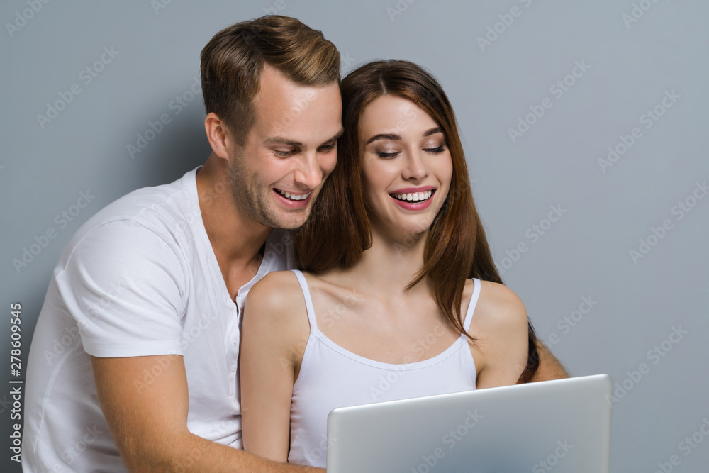 Beautiful young couple using laptop Beautiful young couple using laptop