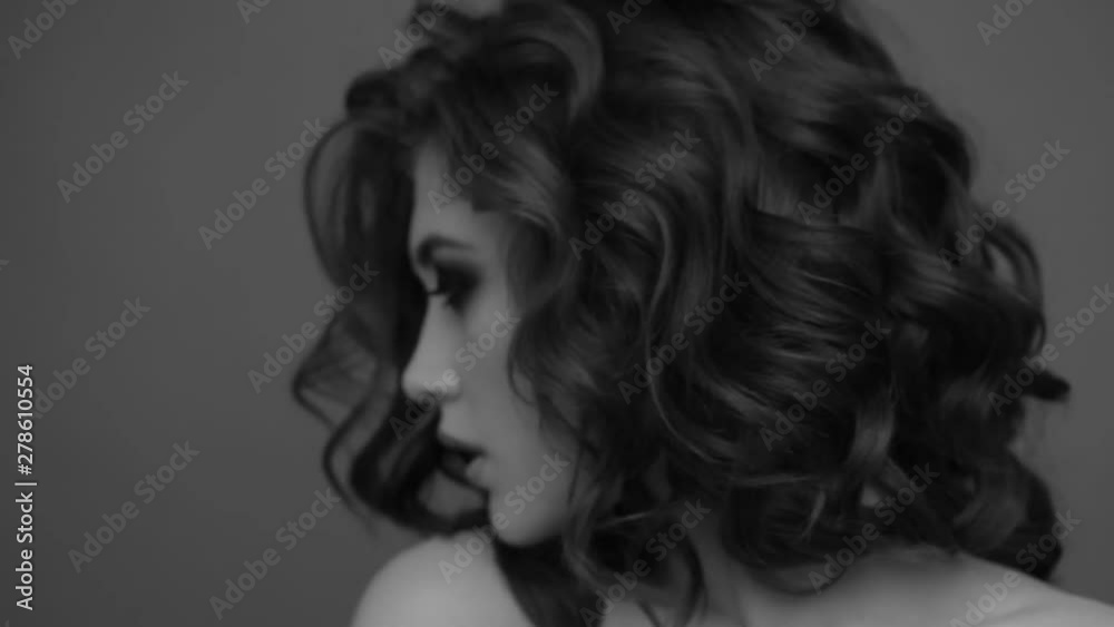Brunette posing on camera. Black and white video. Emotions girls with a slight flirtation.
