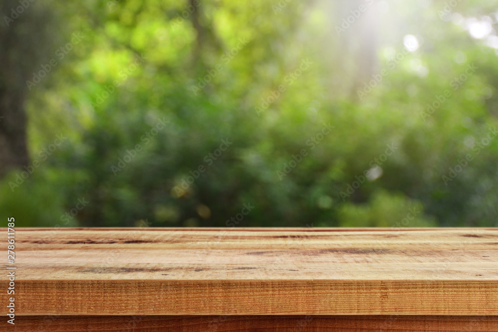 Blurred abstract green bokeh and wooden table background. Blurred abstract green bokeh and wooden table background.