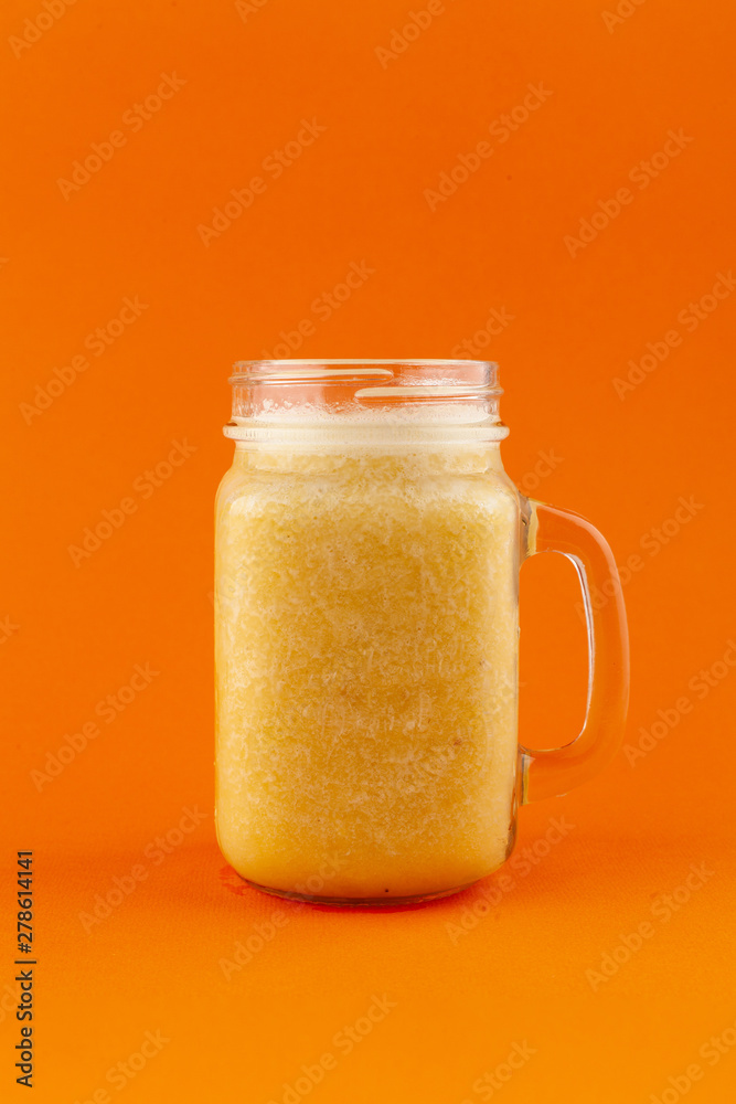 Exotic smoothie with banana, mango and orange, isolated on bright background Exotic smoothie with banana, mango and orange, isolated on bright background