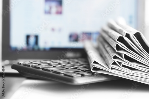 Newspapers and Laptop. Different Concepts for News -  Network or Traditional Tabloid Journals. Data Sources - Electronic Screen of Computer or Paper Pages of Magazines, Internet or Papers 