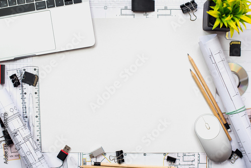 Architectural plans, pencil and ruler on the table. Laptop and workplace accessories. Place for your text.